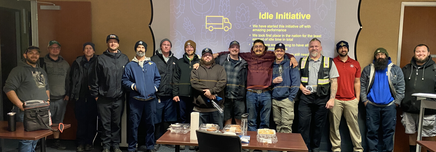 Redding team posing for picture in front of Idle Initiative slide being projected on the wall