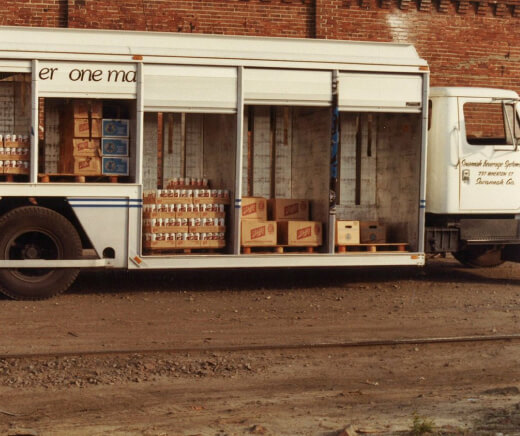 Beer truck parked with side doors open showing cases of Schlitz beer inside