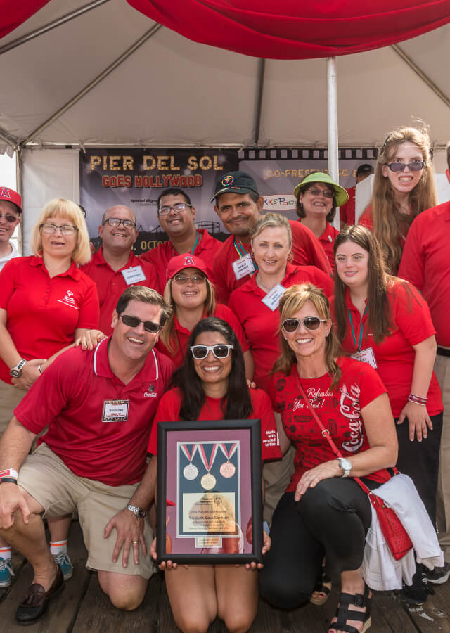 Coca-Cola team poses with special olympics participants at Los Angeles Special Olympics event